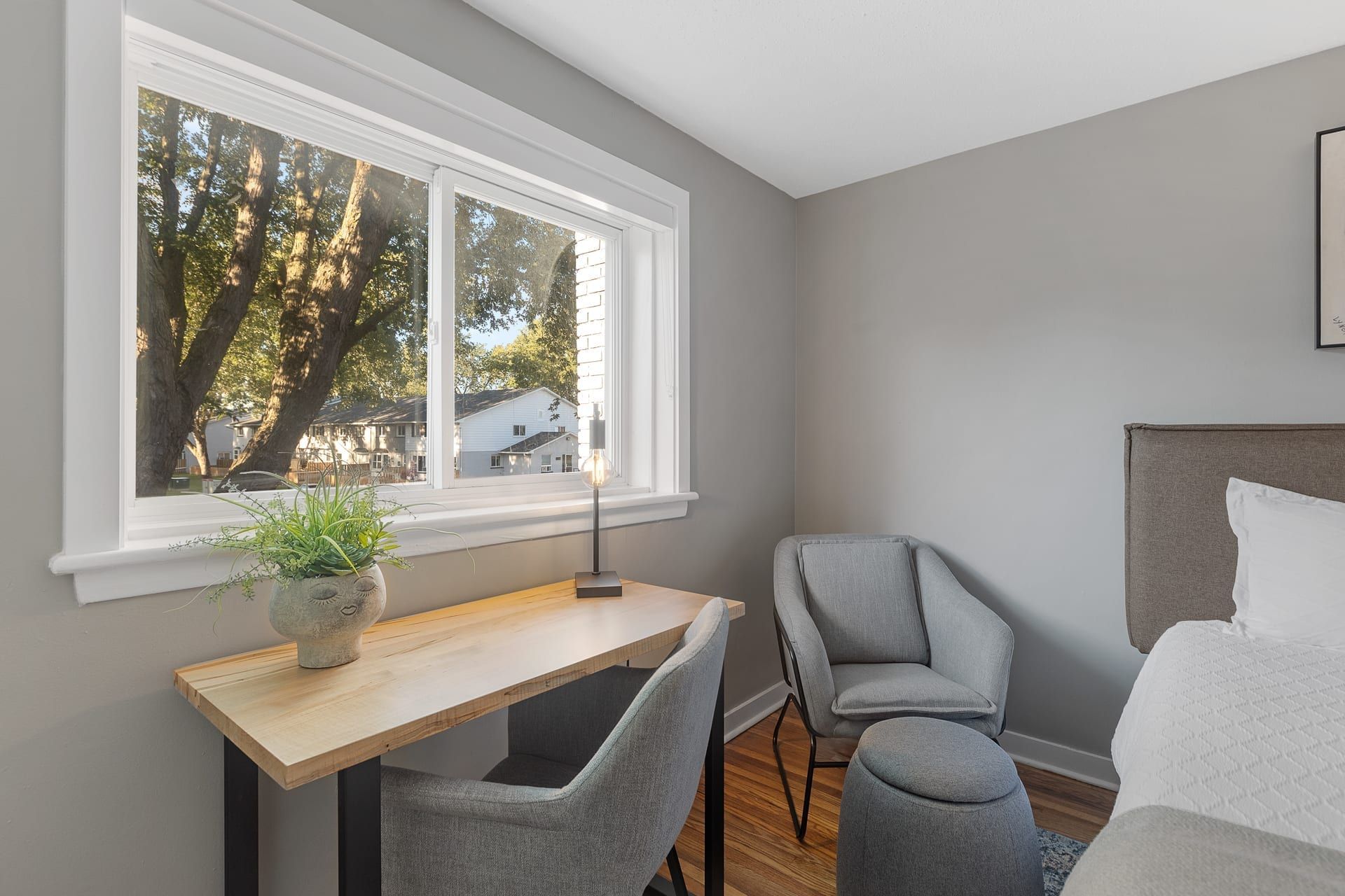 Woodroffe Towns: bedroom desk under a wide window looking out to the townhouse rows, furnished townhouse in Nepean, Ottawa
