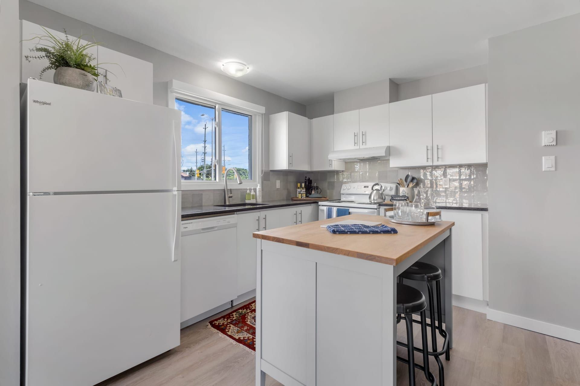 Woodroffe Towns: kitchen with fridge, dishwasher and butcher-block island, furnished townhouse in Nepean, Ottawa